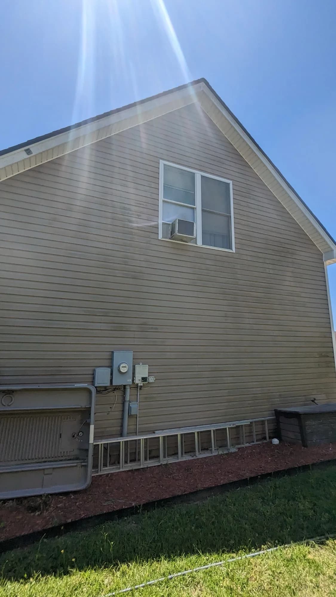 Tan house siding looking dull and dirty before washing